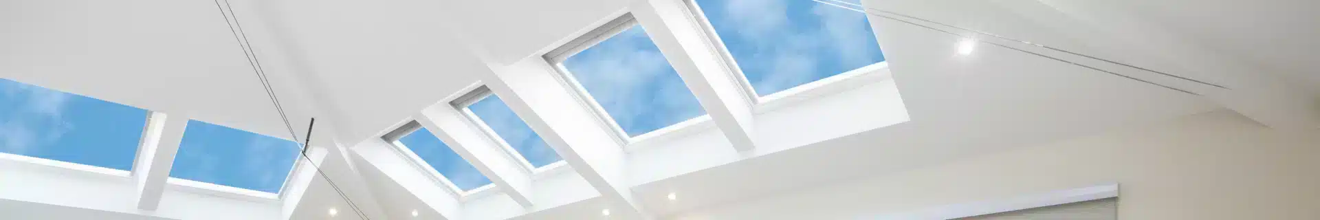 VELUX Skylights in a row with blue sky.